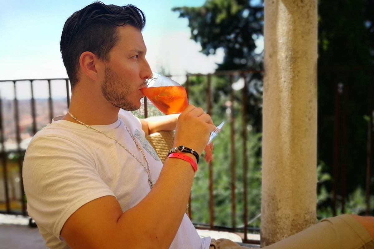 Beautiful man drinking Aperol Spritz